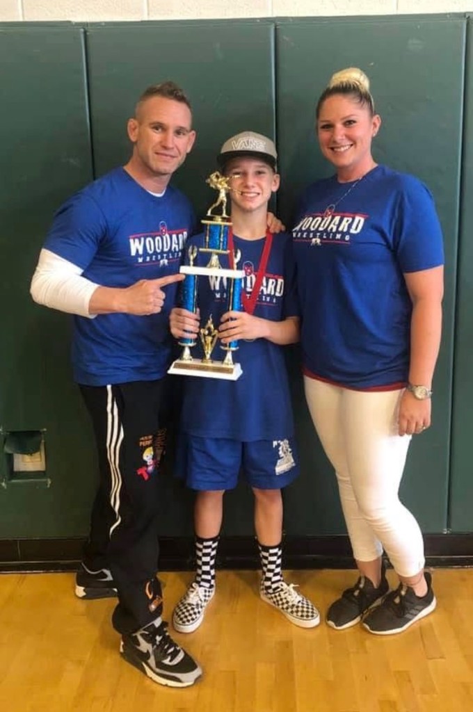 Caden Perry with family and a wrestling trophy